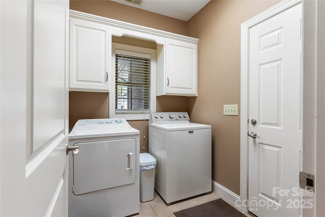 laundry room with cabinet space, washing machine and dryer, light tile patterned flooring, and baseboards