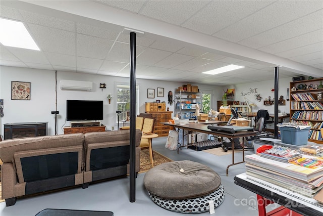 below grade area featuring a drop ceiling, healthy amount of natural light, and a wall mounted air conditioner