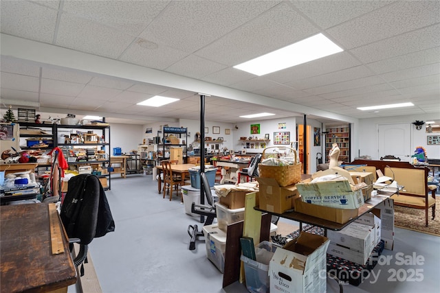 office area with a paneled ceiling and finished concrete flooring
