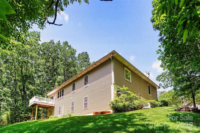 view of side of property featuring a wooden deck and a yard