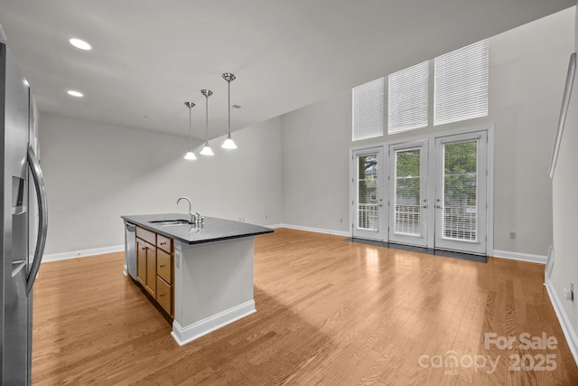 120F Steinbeck Way, Mooresville, NC 28117 - kitchen with a sink, stainless steel appliances, dark countertops, light wood-type flooring, and baseboards