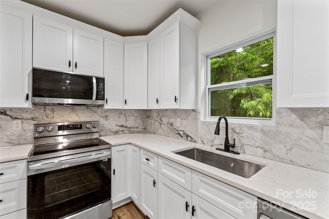 60 Valley St NW, Concord, NC 28025 - kitchen with appliances with stainless steel finishes, a sink, white cabinets, and decorative backsplash