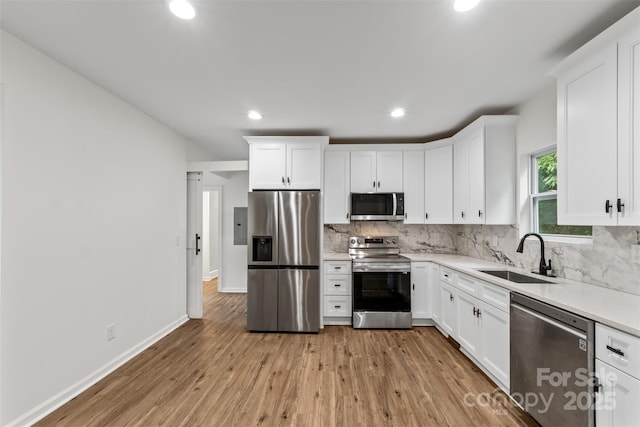 60 Valley St NW, Concord, NC 28025 - kitchen featuring stainless steel appliances, a sink, tasteful backsplash, recessed lighting, and light wood-type flooring