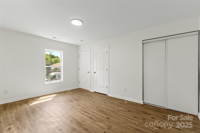 60 Valley St NW, Concord, NC 28025 - unfurnished bedroom with wood finished floors and baseboards