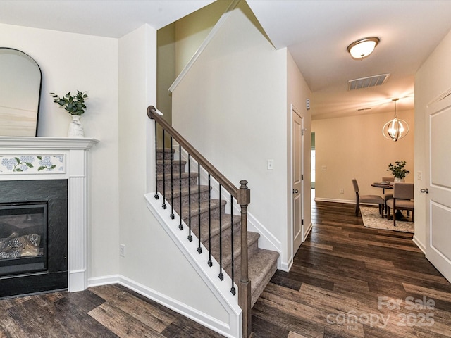 134 Kerri Dawn Ln Unit 117, Locust, NC 28097 - stairs with wood finished floors, baseboards, a glass covered fireplace, and a chandelier