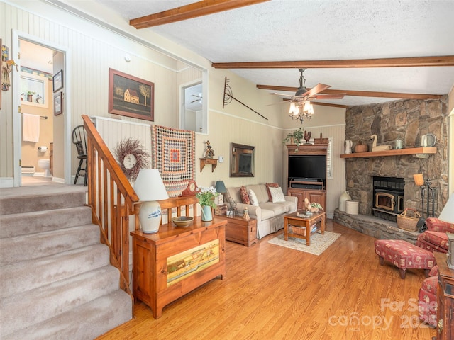 227 Soco Acres Rd, Maggie Valley, NC 28751 - living area featuring light wood-type flooring, beamed ceiling, a ceiling fan, stairs, and a textured ceiling