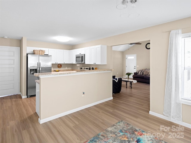 87 Markley Dr, Flat Rock, NC 28731 - kitchen featuring stainless steel appliances, light wood-style flooring, white cabinetry, and baseboards