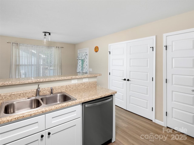 87 Markley Dr, Flat Rock, NC 28731 - kitchen featuring dishwasher, a sink, light countertops, light wood finished floors, and white cabinetry