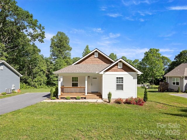 87 Markley Dr, Flat Rock, NC 28731 - view of front of home featuring covered porch, a front yard, roof with shingles, asphalt driveway, and central AC unit