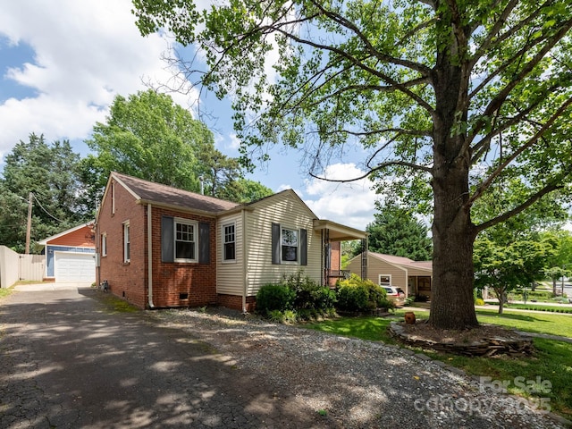 ranch-style house featuring crawl space, an outdoor structure, a garage, fence, and brick siding