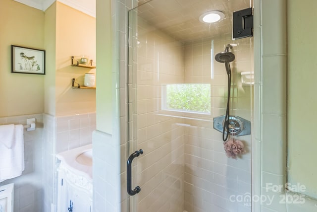 full bath with a shower stall, a wainscoted wall, and vanity