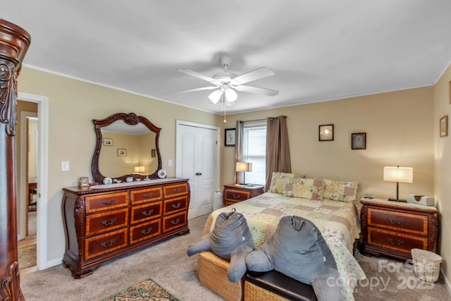 carpeted bedroom featuring ceiling fan, ornamental molding, a closet, and baseboards