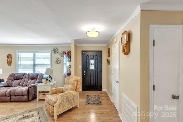 foyer entrance featuring light wood-type flooring, ornamental molding, and baseboards