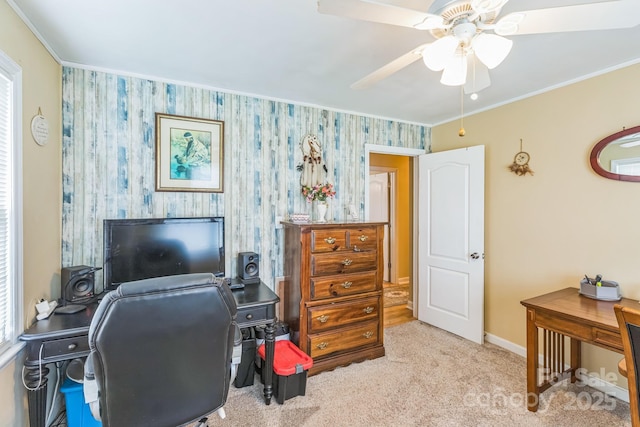 carpeted home office featuring ceiling fan, crown molding, baseboards, and wallpapered walls