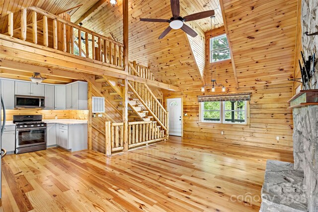 2097 Pinnacle Pkwy Unit 14, Union Mills, NC 28167 - unfurnished living room with high vaulted ceiling, wooden walls, a ceiling fan, light wood-type flooring, and stairs