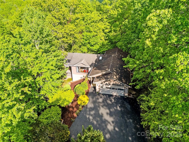 aerial view of property and surrounding area with property parcel outlined and a heavily wooded area