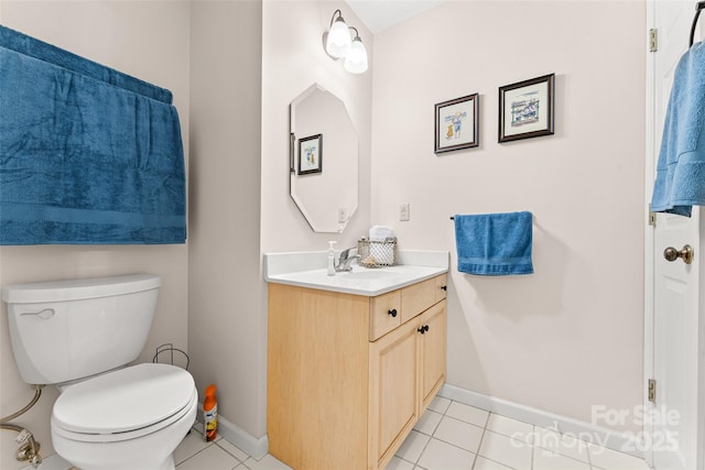 bathroom featuring tile patterned floors, baseboards, toilet, and vanity