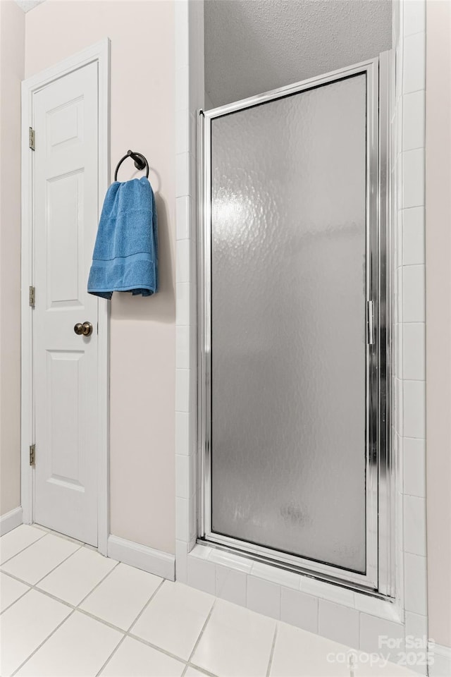 full bath with a stall shower and baseboards