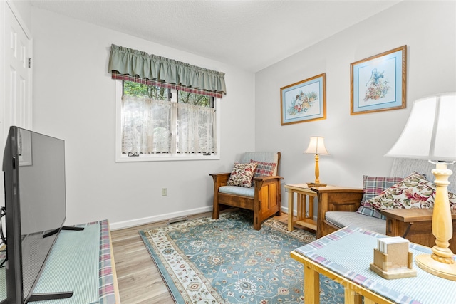 living area featuring light wood-style floors and baseboards