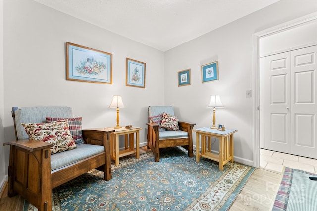 sitting room with baseboards and wood finished floors