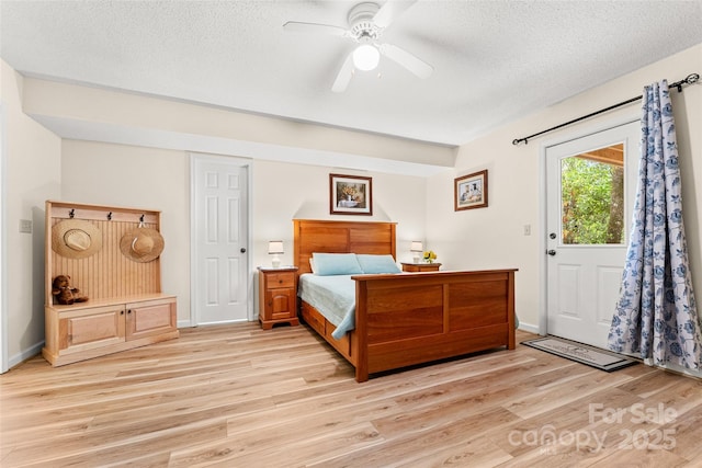 bedroom with light wood finished floors, a textured ceiling, baseboards, and a ceiling fan