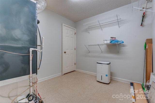 miscellaneous room featuring baseboards, a textured ceiling, and tile patterned floors