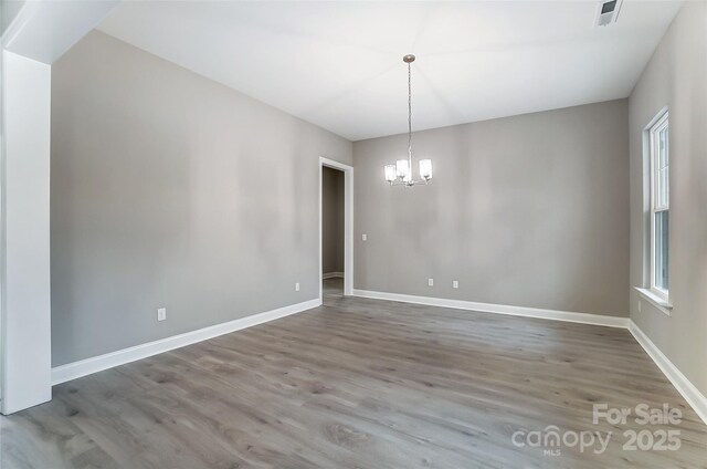 7517 Lancaster Hwy Unit 5, Waxhaw, NC 28173 - unfurnished dining area featuring a chandelier, wood finished floors, and baseboards