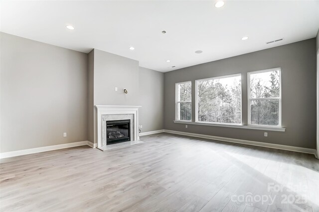 7517 Lancaster Hwy Unit 5, Waxhaw, NC 28173 - unfurnished living room featuring light wood-style flooring, a high end fireplace, baseboards, and recessed lighting
