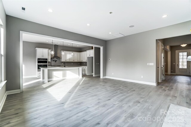 7517 Lancaster Hwy Unit 5, Waxhaw, NC 28173 - unfurnished living room with a sink, light wood-style floors, baseboards, and recessed lighting