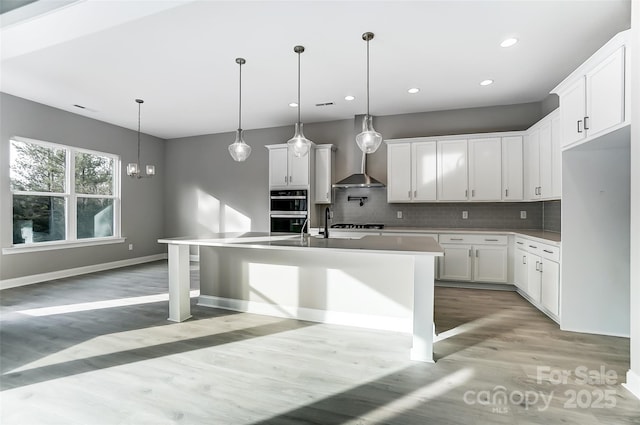 7517 Lancaster Hwy Unit 5, Waxhaw, NC 28173 - kitchen featuring light wood-type flooring, double oven, backsplash, recessed lighting, and an island with sink