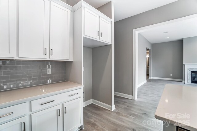 7517 Lancaster Hwy Unit 5, Waxhaw, NC 28173 - kitchen with white cabinetry, backsplash, baseboards, light wood finished floors, and light countertops