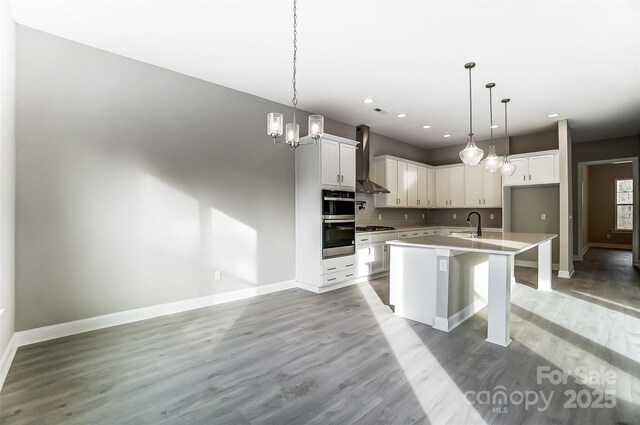 7517 Lancaster Hwy Unit 5, Waxhaw, NC 28173 - kitchen with wall chimney exhaust hood, gas stovetop, baseboards, light wood finished floors, and backsplash