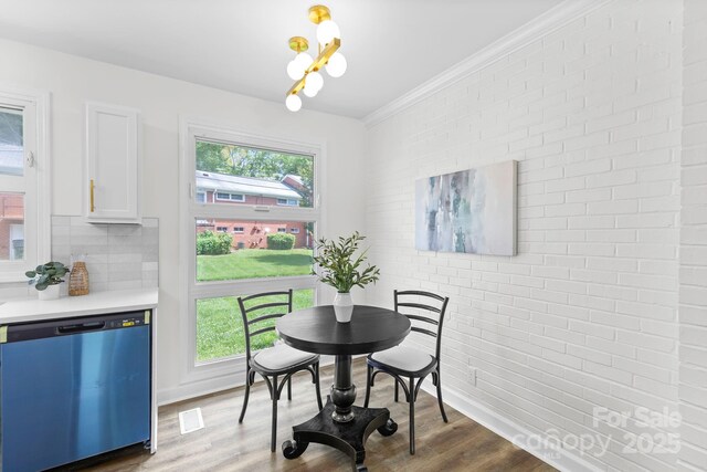 4226 Randolph Rd, Charlotte, NC 28211 - dining space featuring brick wall, wood finished floors, and crown molding