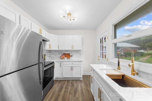 4226 Randolph Rd, Charlotte, NC 28211 - kitchen with stainless steel appliances, a sink, under cabinet range hood, white cabinetry, and decorative backsplash