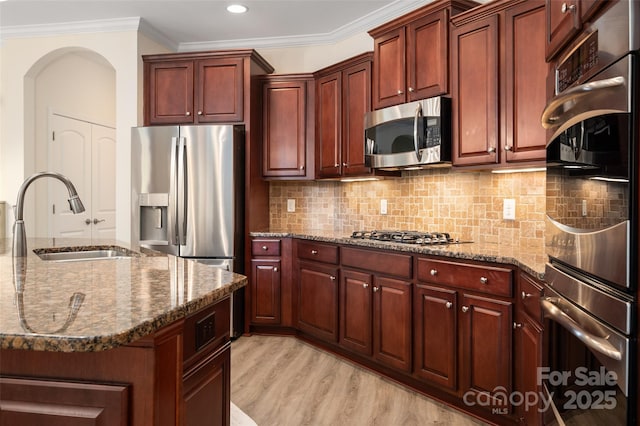 10502 Old Ardrey Kell Rd, Charlotte, NC 28277 - kitchen with a sink, stainless steel appliances, arched walkways, dark stone countertops, and ornamental molding