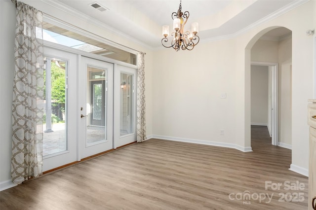 10502 Old Ardrey Kell Rd, Charlotte, NC 28277 - unfurnished dining area with light wood-style floors, arched walkways, a chandelier, crown molding, and baseboards