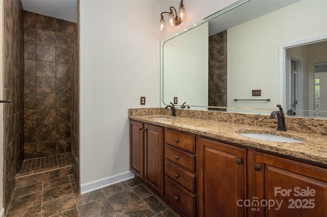 10502 Old Ardrey Kell Rd, Charlotte, NC 28277 - full bath with baseboards, double vanity, a tile shower, and stone finish floors
