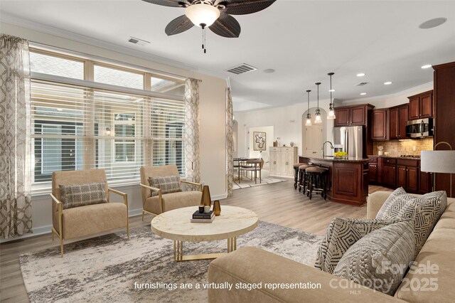 10502 Old Ardrey Kell Rd, Charlotte, NC 28277 - living area featuring a ceiling fan, light wood finished floors, crown molding, baseboards, and recessed lighting