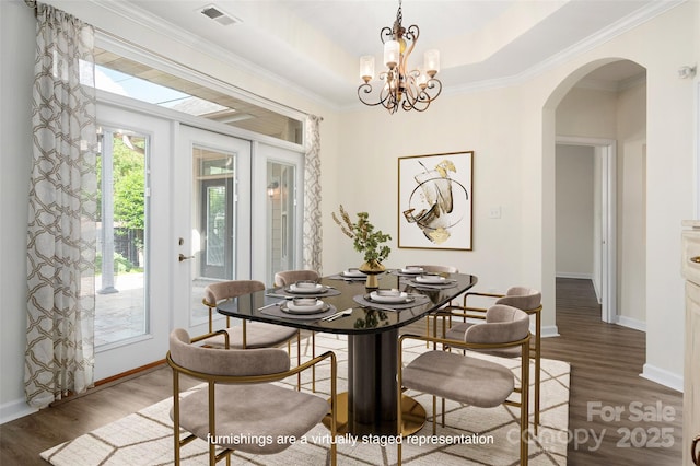 10502 Old Ardrey Kell Rd, Charlotte, NC 28277 - dining space with arched walkways, wood finished floors, baseboards, ornamental molding, and a chandelier