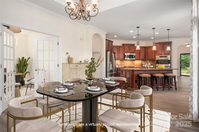 10502 Old Ardrey Kell Rd, Charlotte, NC 28277 - dining room featuring a chandelier, crown molding, light wood-style flooring, and recessed lighting