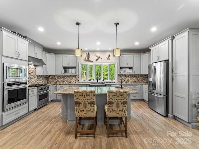 4290 Black Bear Trl, Morganton, NC 28655 - kitchen featuring appliances with stainless steel finishes, a center island with sink, gray cabinetry, light stone countertops, and a sink
