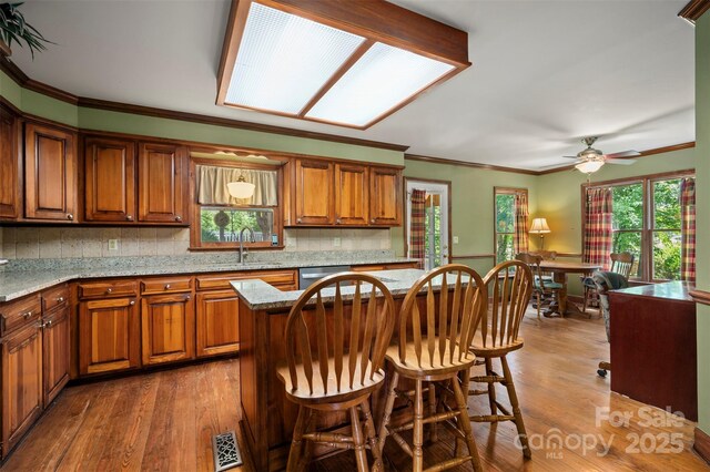 312 Briarwood Dr, Rutherfordton, NC 28139 - kitchen featuring brown cabinets, dark wood-style floors, a sink, crown molding, and light stone countertops