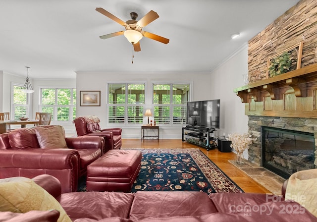 2606 Walker Rd, Matthews, NC 28105 - living room featuring crown molding, a ceiling fan, a stone fireplace, and wood finished floors