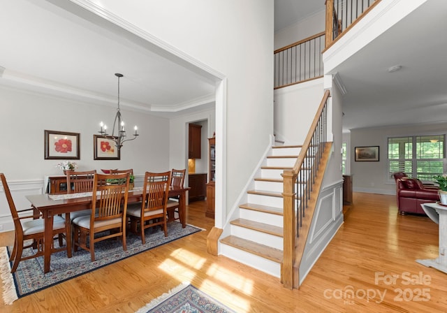 2606 Walker Rd, Matthews, NC 28105 - dining space with crown molding, stairs, light wood-style flooring, and a chandelier