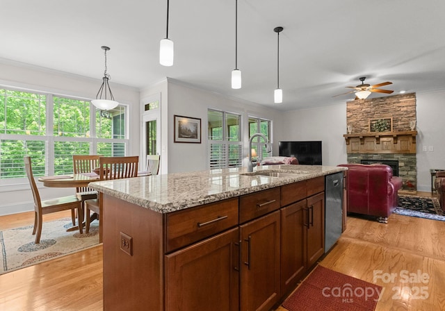2606 Walker Rd, Matthews, NC 28105 - kitchen with a sink, a stone fireplace, dishwasher, a ceiling fan, and light wood-style floors