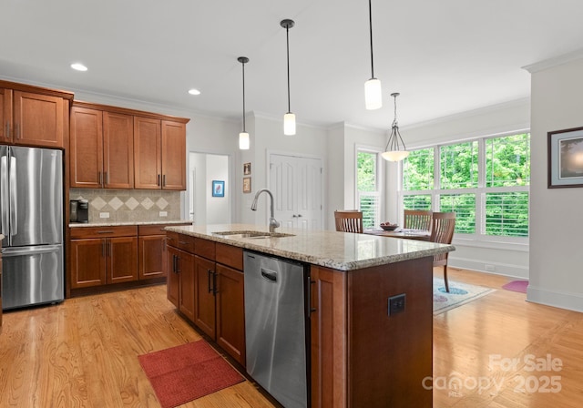 2606 Walker Rd, Matthews, NC 28105 - kitchen featuring appliances with stainless steel finishes, a sink, crown molding, light wood-type flooring, and brown cabinetry