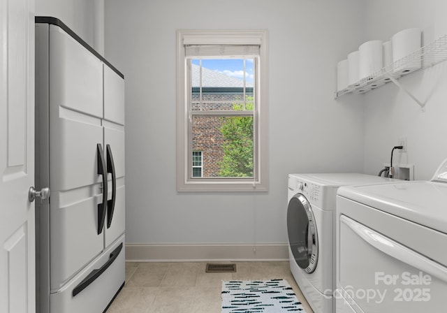 2606 Walker Rd, Matthews, NC 28105 - laundry area featuring independent washer and dryer, baseboards, light tile patterned floors, and cabinet space