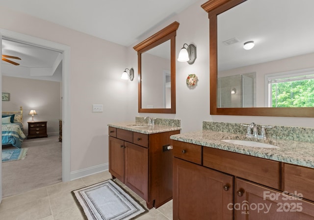 2606 Walker Rd, Matthews, NC 28105 - ensuite bathroom with tile patterned floors, two vanities, ceiling fan, a shower, and baseboards