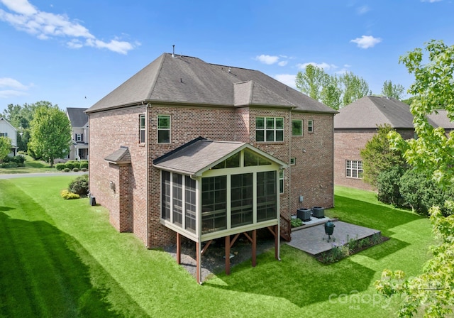 2606 Walker Rd, Matthews, NC 28105 - rear view of property featuring a patio area, a sunroom, a yard, brick siding, and roof with shingles