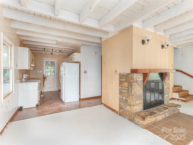 318 Sandsridge Way, Waynesville, NC 28785 - unfurnished living room with beamed ceiling, a stone fireplace, light floors, stairway, and wooden walls